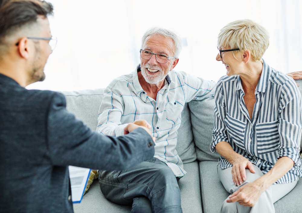 Adviser With Mature Couple Shaking Hands